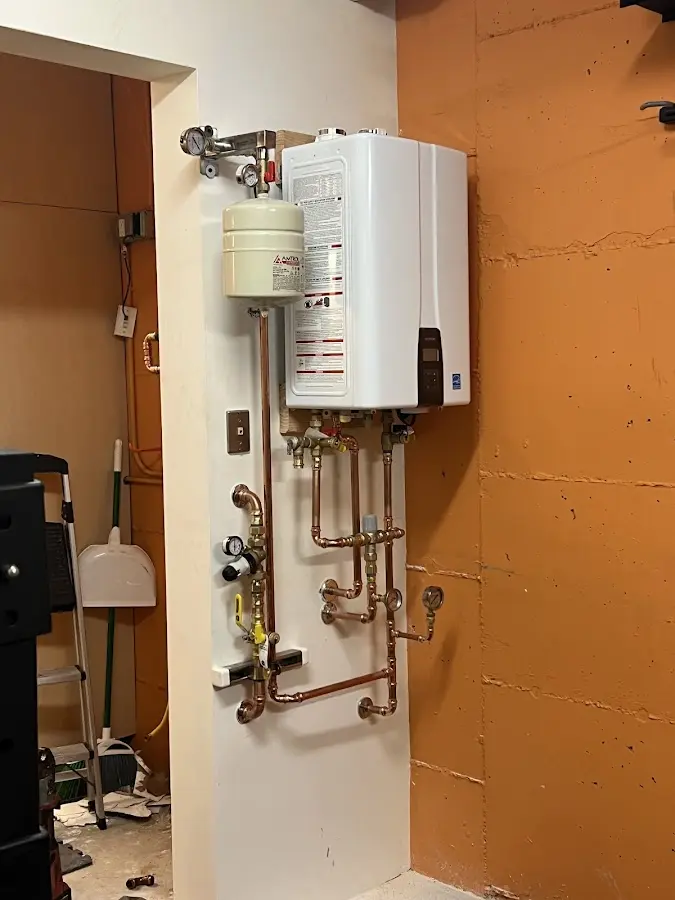 Plumbing technician inspecting water heater connections in Niceville